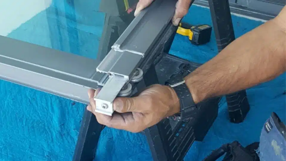 Warped aluminum sliding door track with debris buildup common in Austin homes