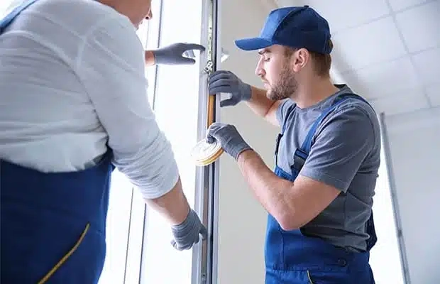 Technician inspecting a worn door sweep
