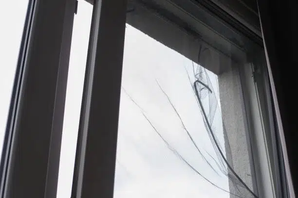 Sun damaged torn fiberglass window screen mesh in a bent aluminum frame in Dallas TX